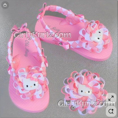 Pink sandals with Hello Kitty design on a gray background